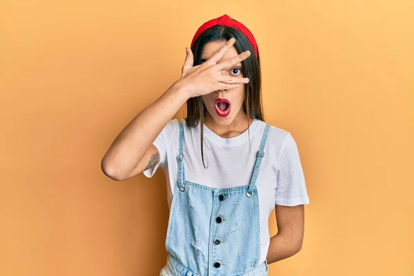 Menina Hispânica Jovem Vestindo Roupas Casuais Espreitando Choque Cobrindo Rosto — Fotografia de Stock