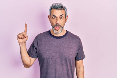 Yakışıklı, orta yaşlı, beyaz saçlı, işaret parmağıyla işaret eden, şaşırmış, şaşırmış, şaşırmış, şaşkınlık ifadesi, korku ve heyecanlı yüzü olan bir adam.. 