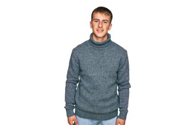 Yüzünde mutlu ve havalı bir gülümseme olan sıradan kıyafetler giyen genç sarışın bir adam. şanslı kişi. 