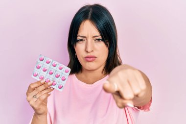 Elinde kamerayı işaret eden haplar tutan genç İspanyol bir kadın ve sen, kendine güvenen ciddi görünüyorsun. 