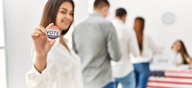 Bir grup genç Amerikalı seçmen oy pusulasına oy veriyor. Gülümseyen ve elinde tutan bir kadın. Seçim merkezinde oy verdim..