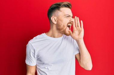 Genç, beyaz tişörtlü, el ele tutuşmuş, bağırıp çağıran genç bir kızıl. iletişim konsepti. 