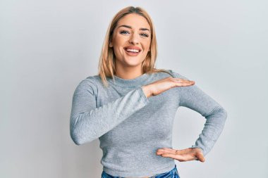 Kafkasyalı genç bir kadın, sıradan kıyafetler giyiyor. Elleriyle işaret ediyor. Ölçü sembolü. Kameraya bakıp gülümsüyor. ölçüm kavramı. 