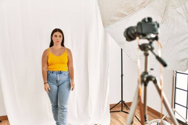 Fotoğrafçılık stüdyosunda model gibi davranan genç ve güzel İspanyol kadın üzgün ve endişeli, sinirli ve korkmuş. hüzünlü ifade. 