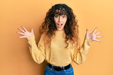 Genç İspanyol kız gündelik giysiler giyip çılgınlığı kutluyor ve başarıya hayret ediyor kolları açık ve gözleri açık heyecanla haykırıyor. Kazanan konsept 