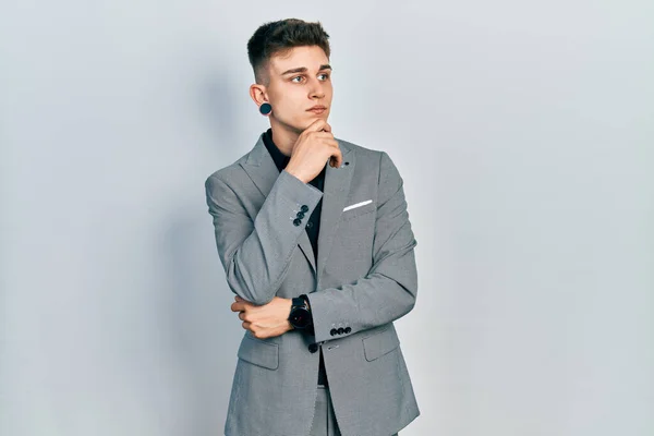 Fiatal Kaukázusi Fiú Kitágult Fülekkel Üzleti Kabátot Visel Kezével Állán — Stock Fotó