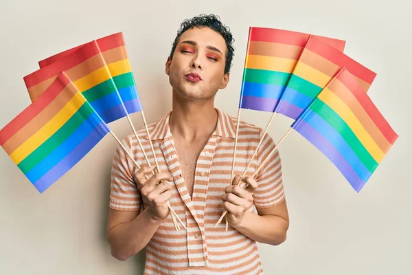 Hombre Guapo Usando Maquillaje Sosteniendo Banderas Arco Iris Lgbtq Mirando —  Fotos de Stock