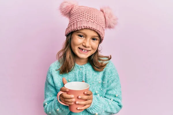 분홍색 머그를 아름다운 소녀가 귀여운 모자를 웃으면서 소리로 있습니다 — 스톡 사진