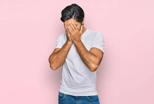 泣きながら手で顔を覆う悲しい表情のカジュアルな白いTシャツを着た若いヒスパニック系の男 うつ病の概念 — ストック写真