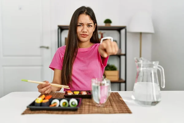 若いですブルネット女性食べる寿司箸を指して不満とカメラに不満 怒っていると激怒あなたと一緒に — ストック写真