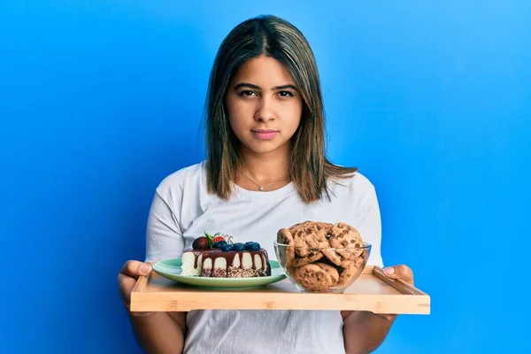 Mulher Latina Jovem Segurando Doces Bolo Biscoitos Cético Nervoso Franzindo — Fotografia de Stock
