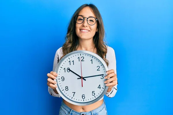 Mulher Morena Jovem Segurando Grande Relógio Sorrindo Com Sorriso Feliz — Fotografia de Stock