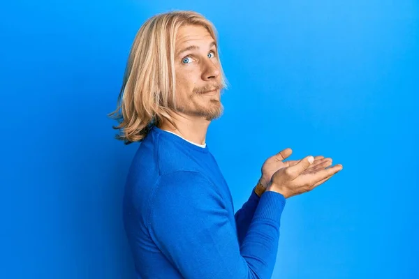 Caucasian Young Man Long Hair Presenting Open Palms Holding Something — Stock Photo, Image