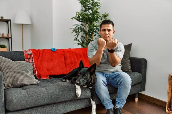 Jovem Latino Homem Cão Sentado Sofá Casa Pronto Para Lutar — Fotografia de Stock