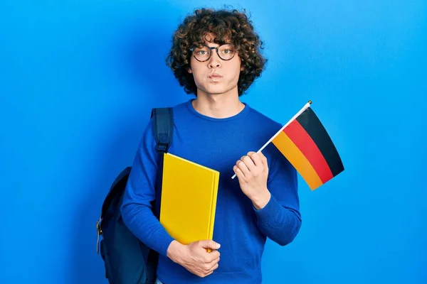 Guapo Joven Estudiante Intercambio Sosteniendo Bandera Alemania Soplando Mejillas Con —  Fotos de Stock