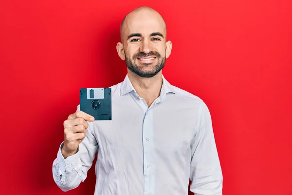 Junger Glatzköpfiger Mann Mit Diskette Sieht Positiv Und Glücklich Stehend — Stockfoto