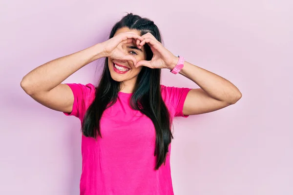 Gündelik Pembe Tişört Giyen Elleri Parmaklarıyla Kalp Şeklinde Gülümseyen Genç — Stok fotoğraf