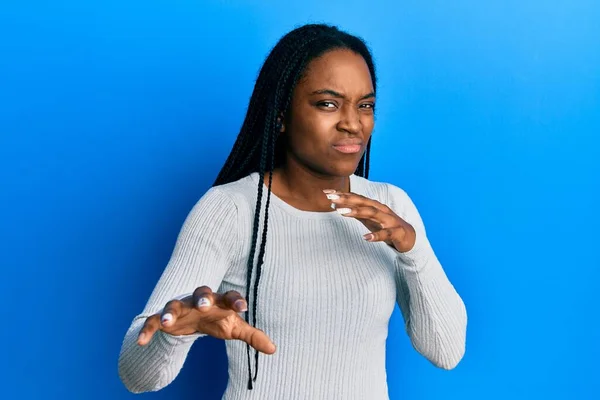 カジュアルな白いセーターを着て編組髪を持つアフリカ系アメリカ人の女性は嫌悪反応のために嫌悪感の表情 不満と恐ろしい嫌な顔をしている 手を挙げて — ストック写真