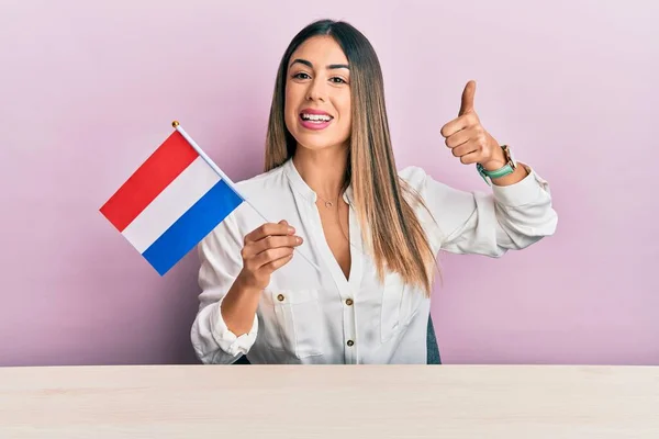 Молодая Латиноамериканка Флагом Голландии Сидит Столе Улыбаясь Счастливой Позитивной Большой — стоковое фото