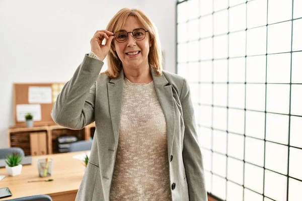 Mujer Negocios Mediana Edad Sonriendo Feliz Sosteniendo Gafas Oficina —  Fotos de Stock