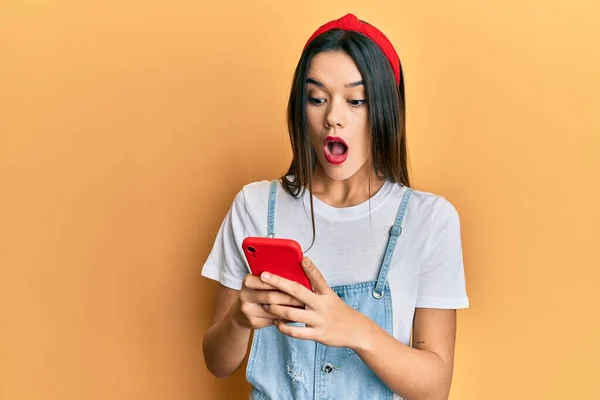 Menina Hispânica Jovem Usando Smartphone Com Medo Chocado Com Expressão — Fotografia de Stock