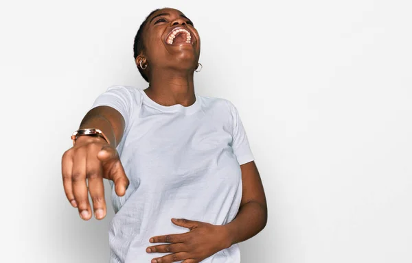 若いアフリカ系アメリカ人の女性が白いTシャツを着て笑いながら 手を体の上に置きながらカメラに指を向け恥の表情 — ストック写真