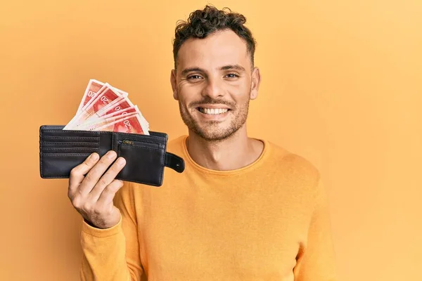 Joven Hombre Hispano Sosteniendo Billetera Con Shekels Israel Mirando Positiva —  Fotos de Stock