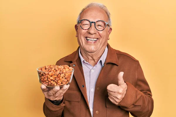 Hombre Mayor Con Pelo Gris Sosteniendo Cacahuetes Fritos Sonriendo Feliz —  Fotos de Stock