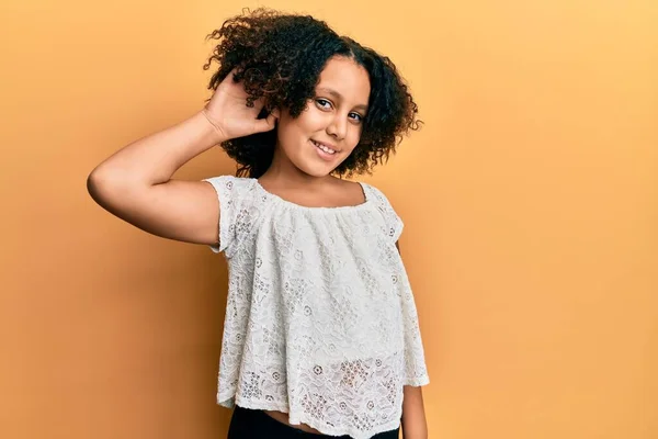 耳に噂やゴシップに耳を傾け手で笑みを浮かべてカジュアルな服を着てアフロ髪を持つ若い女の子 聴覚障害の概念 — ストック写真
