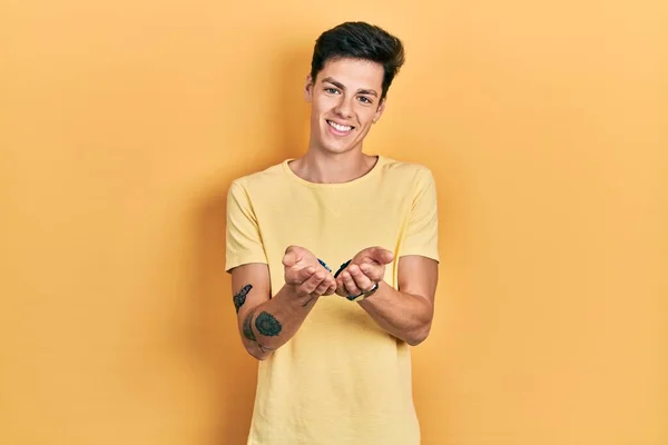 Elleri Avuçlarında Gülümseyen Günlük Sarı Tişörtler Giyen Spanyol Genç Adam — Stok fotoğraf