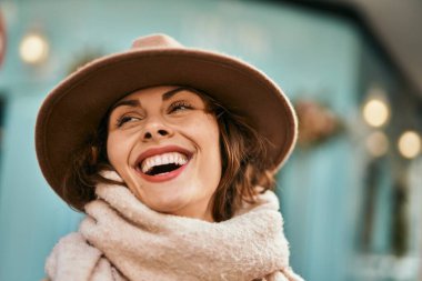 Şık giyinen genç İspanyol kadın şehirde dikiliyor..