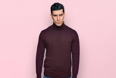 Balıkçı yaka kazak giyen yakışıklı, kuşkucu ve gergin sorunlu bir İspanyol. negatif kişi. 