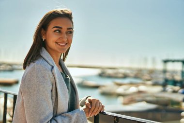 Genç İspanyol kız gülümsüyor mutlu bir şekilde kentteki korkuluklara yaslanıyor..