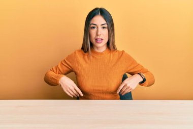 Gündelik kıyafetler giyen genç İspanyol kadın masada oturuyor. Uykulu ve yorgun görünüyor. Yorgunluktan bitkin düşmüş, akşamdan kalma, tembel gözlü.. 