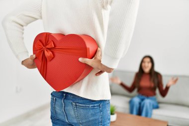 Genç İspanyol çift gülümsüyor. Sevgililer günü hediyesiyle mutlu bir sürpriz..