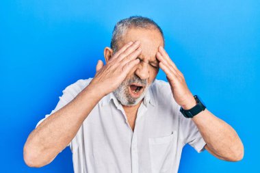 Yakışıklı, sakallı, sıradan, beyaz tişörtlü, başı ağrıyan bir adam. Stres yüzünden. migren ağrısı. 