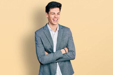 Kollarını kavuşturup kameraya seksi bir ifadeyle, neşeli ve mutlu bir yüzle bakan İspanyol bir iş adamı.. 