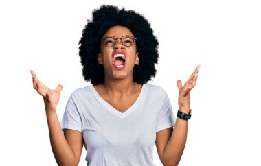 Beyaz bir tişört giyen genç Afro-Amerikalı kadın başarıyı kutlamak için çılgın ve çılgın bir kutlama yapıyor kollarını kaldırmış ve gözlerini kapatmış heyecanla bağırıyor. Kazanan konsept 