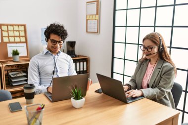 Ofiste çalışırken gülümseyen iki çağrı merkezi ajanı..