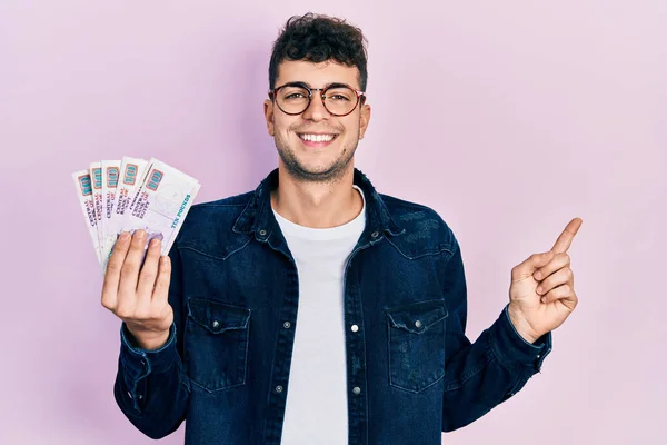 Joven Hispano Sosteniendo Billetes Libras Egipcias Sonriendo Feliz Señalando Con —  Fotos de Stock