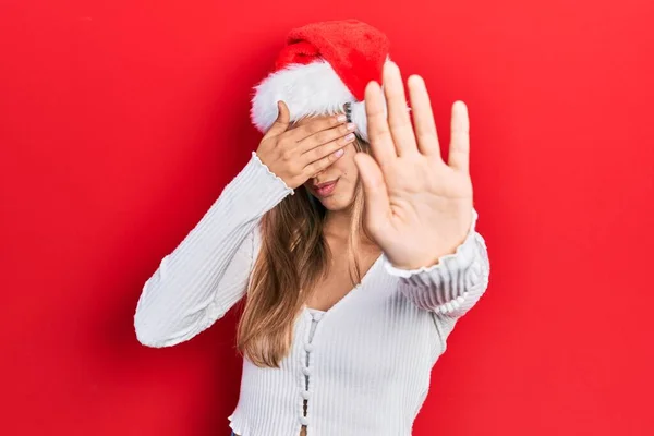 Mulher Hispânica Bonita Vestindo Chapéu Natal Cobrindo Olhos Com Mãos — Fotografia de Stock