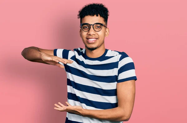 Młody Afroamerykanin Luźnych Ubraniach Okularach Gestykulujący Rękami Pokazujący Duży Duży — Zdjęcie stockowe