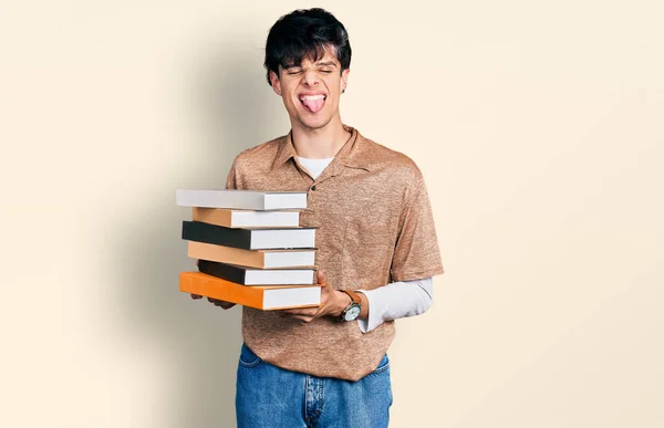 Guapo Hipster Joven Sosteniendo Montón Libros Sacando Lengua Feliz Con —  Fotos de Stock