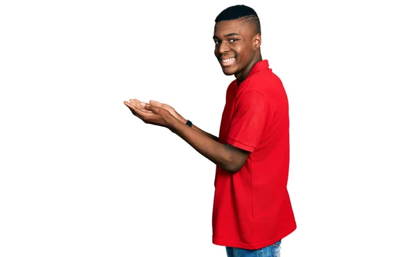 Joven Afroamericano Hombre Vistiendo Casual Camiseta Roja Señalando Lado Con —  Fotos de Stock