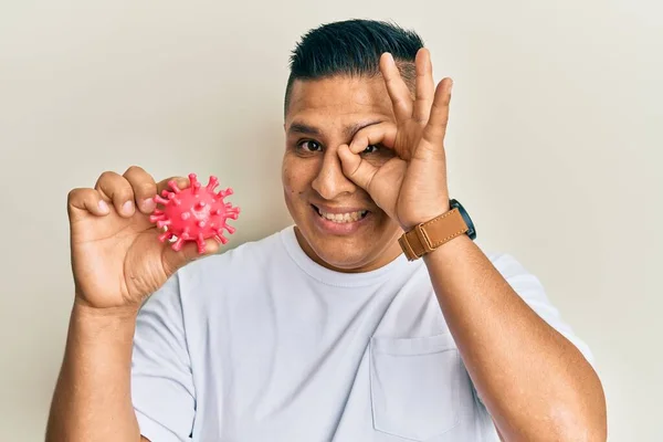 Joven Latino Hombre Celebración Virus Juguete Sonriendo Feliz Haciendo Signo —  Fotos de Stock