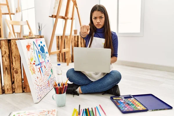 Young Brunette Woman Sitting Floor Art Studio Laptop Pointing Finger — Stock Photo, Image