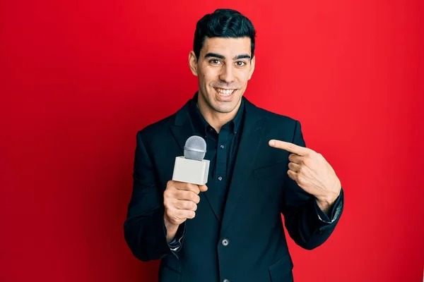 Hezký Hispánec Držící Reportérský Mikrofon Ukazující Prstem Jednoho Samolibého Šťastného — Stock fotografie