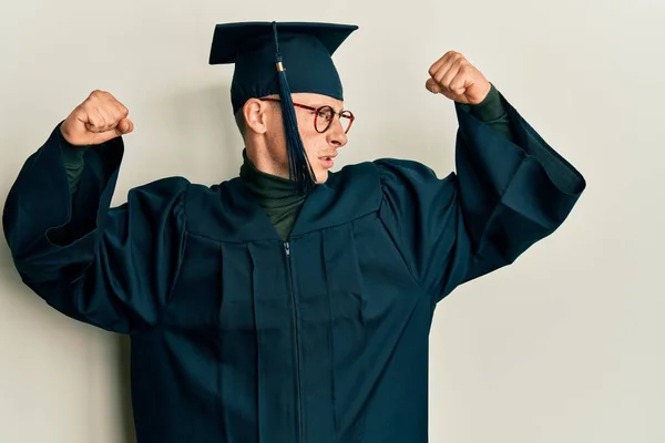 Young Caucasian Man Wearing Graduation Cap Ceremony Robe Showing Arms — Stock Photo, Image
