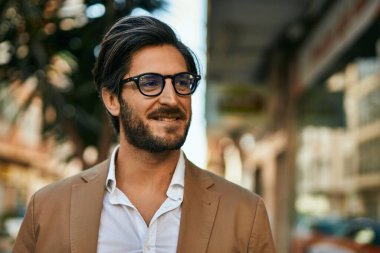 Genç İspanyol işadamı gülümseyerek şehirde mutlu mesut duruyor..