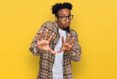 Sakallı, sıradan giyinmiş, gözlüklü, el ele tutuşan, reddeden ve iğrenç bir ifadeyle reddeden Afrikalı genç bir Amerikalı. Dur ve yasakla. 